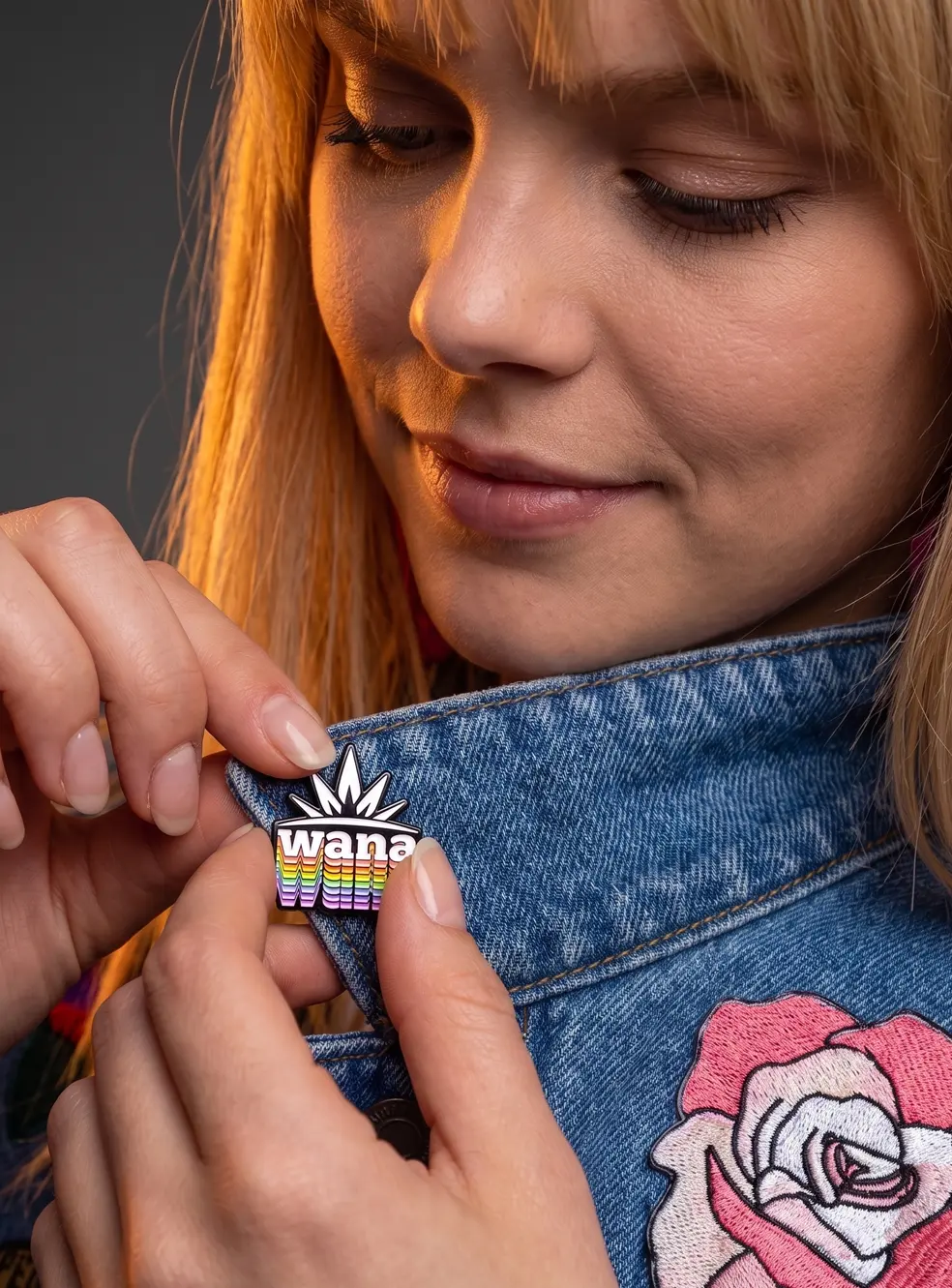 Girl applying custom enamel pin to jacket